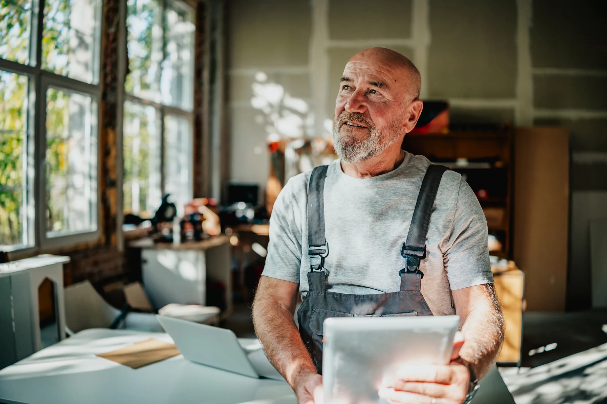 A craftsperson uses a tablet for tasks and projects in his workshop.